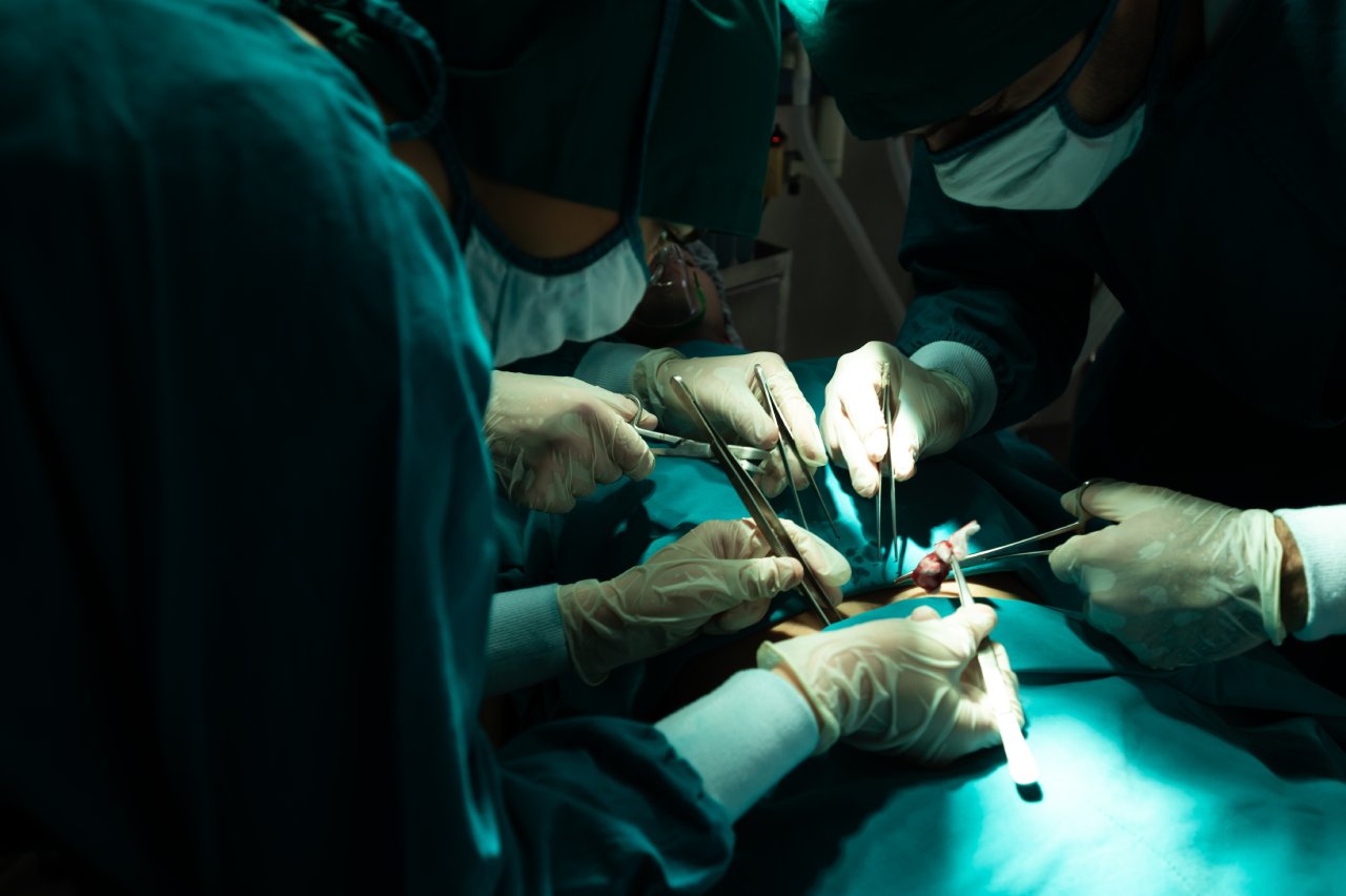 A surgeon performing surgery underneath a large surgical light