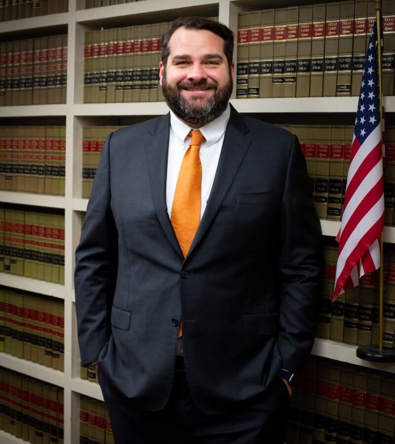 Attorney Ben Bonner standing in front of law books and US flag