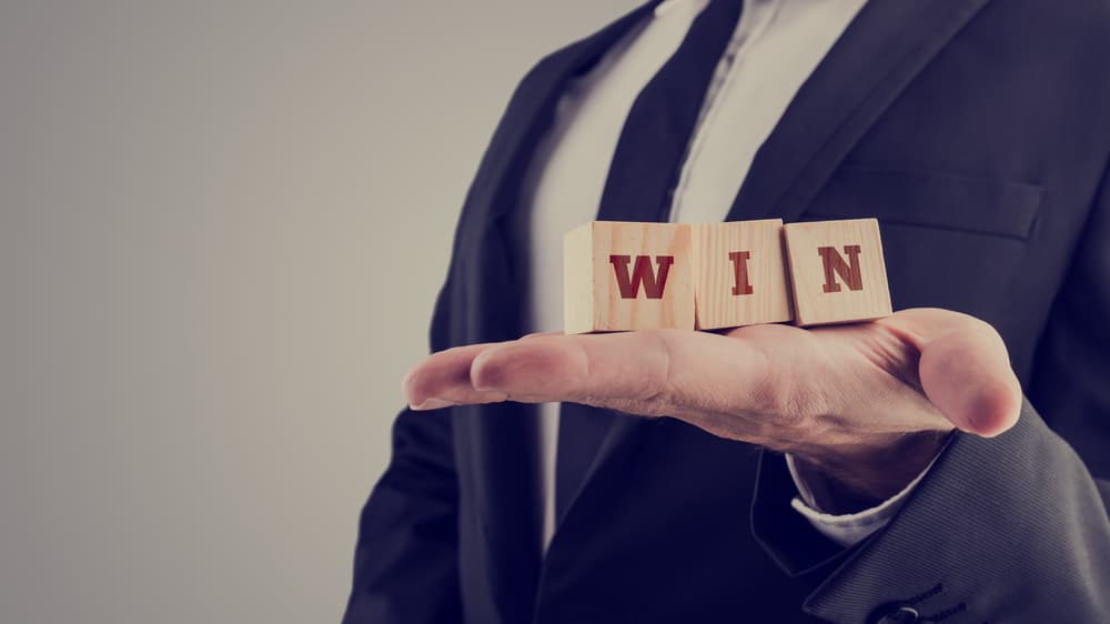 An attorney holding wooden alphabet blocks reading - Win