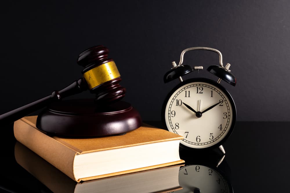 Gavel hammer, clock and book with low light view.